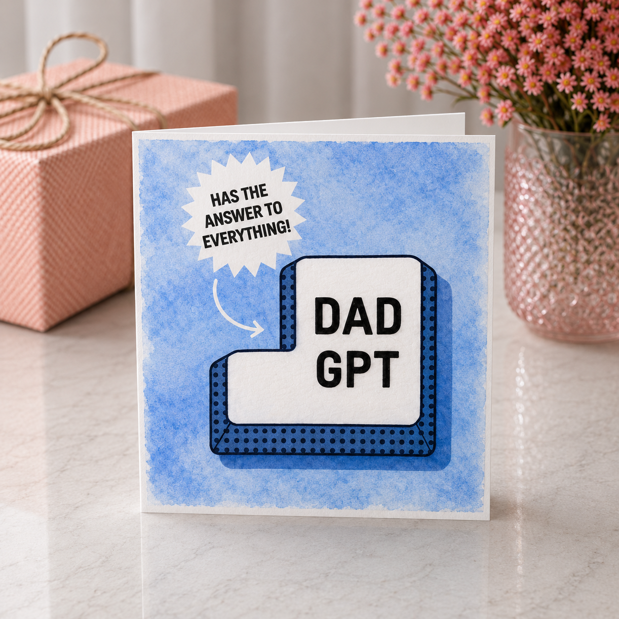 Card with 'DAD GPT' design on a table with a gift and flowers in the background