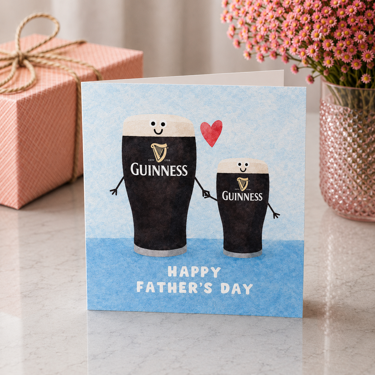 Father's Day card with cartoon Guinness pints and a gift box in the background