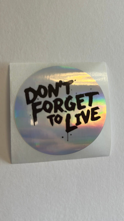 Sticker with 'Don't Forget to Live' text on a white surface