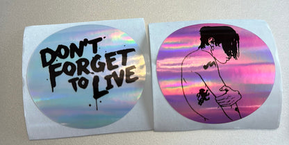 Two round stickers with motivational text and artistic design on a plain background