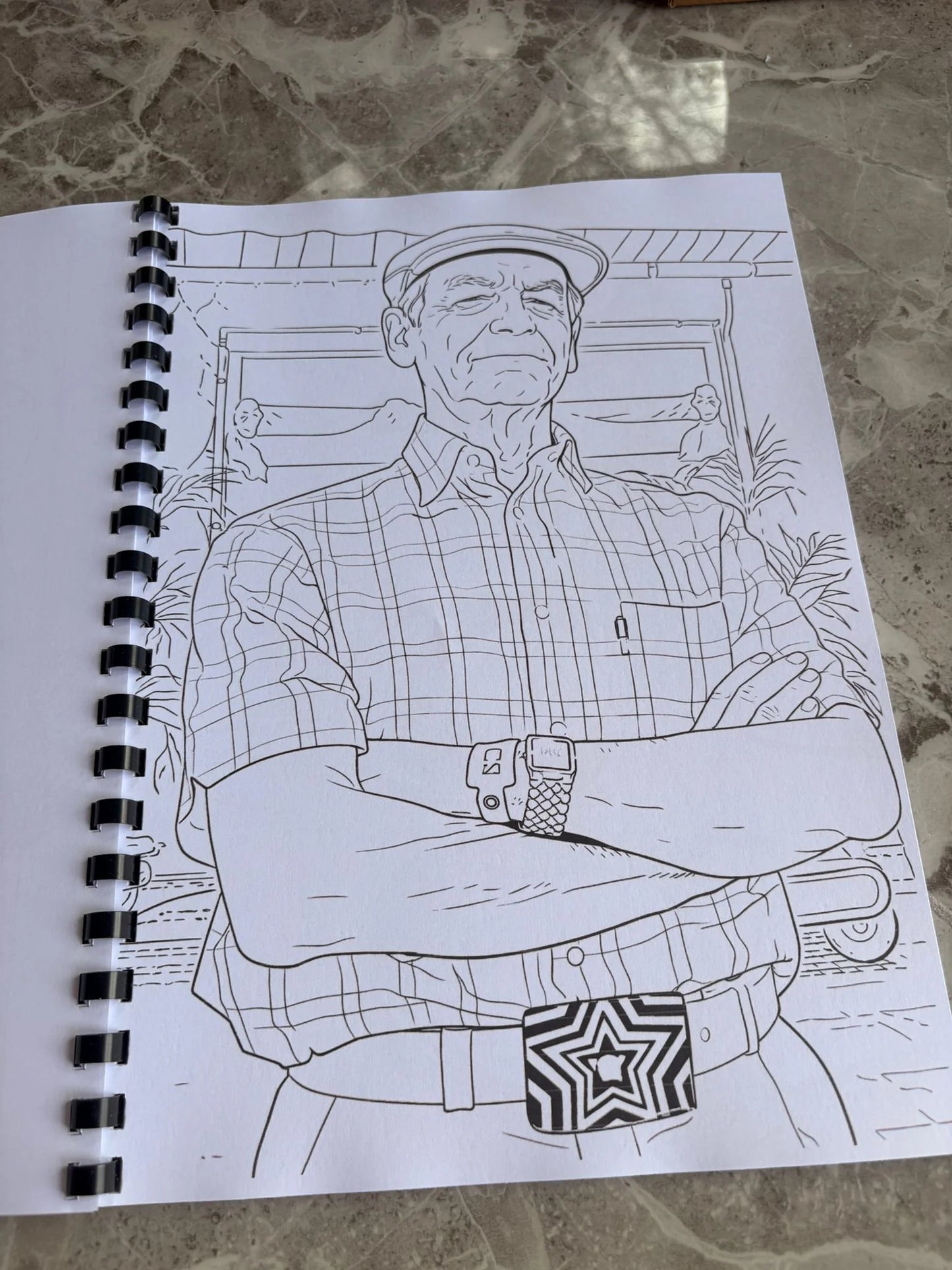 Outline drawing of a person on a spiral-bound notebook with a star design on a textured surface.